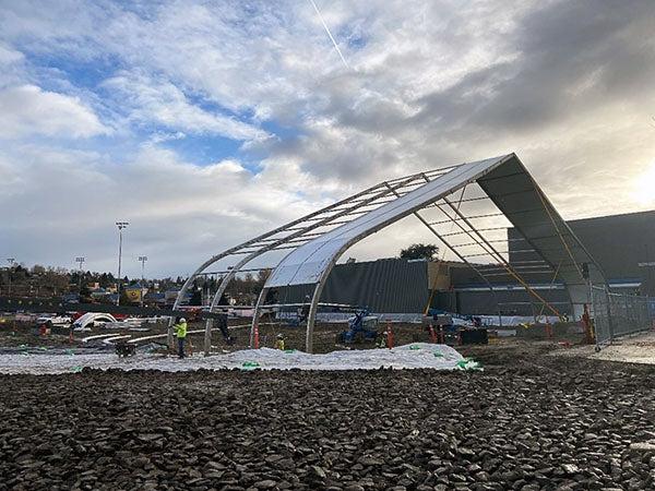 a large frame work is being installed over an area with large rocks